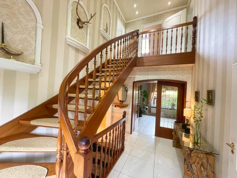 Elegante Holztreppe in einem geräumigen Foyer